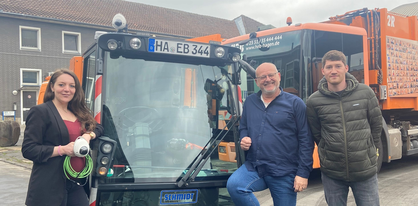 Nicole Flocco, Detlef Liedtke und Frederik Freiheit vom HEB zeigen die mit der Kamera ausgerüstete Kehrmaschine