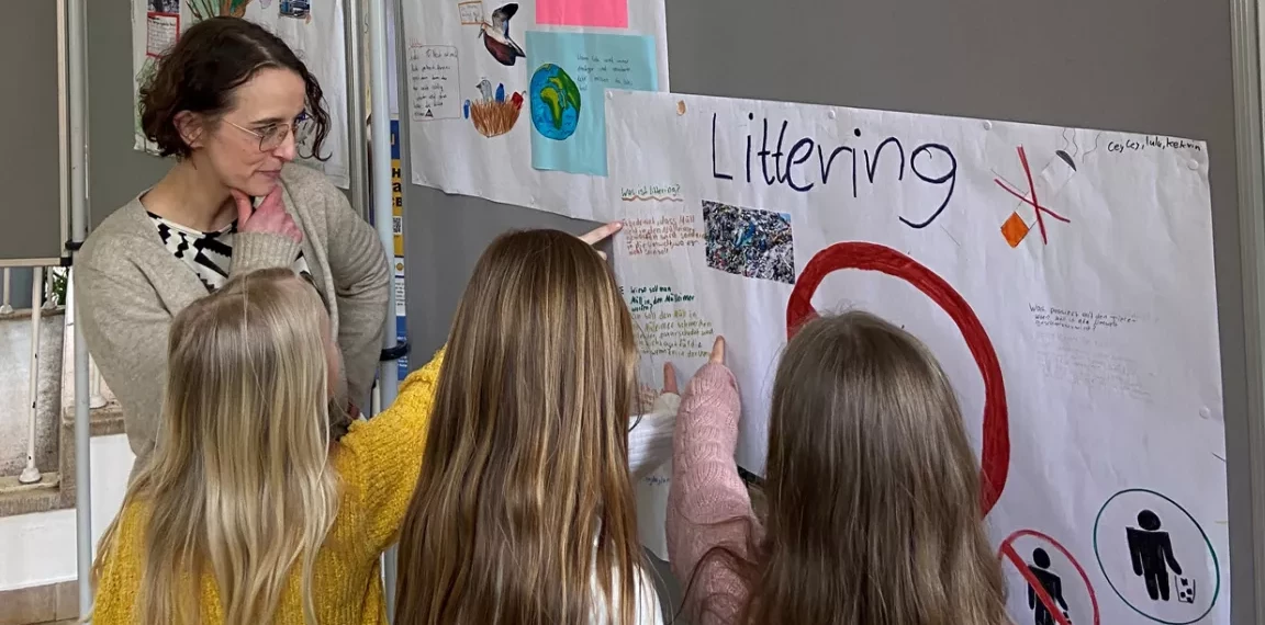 Lehrerin Dr. Elisa Mintert-Jancke mit einigen Schülerinnen der Umwelt AG vor der Ausstellung